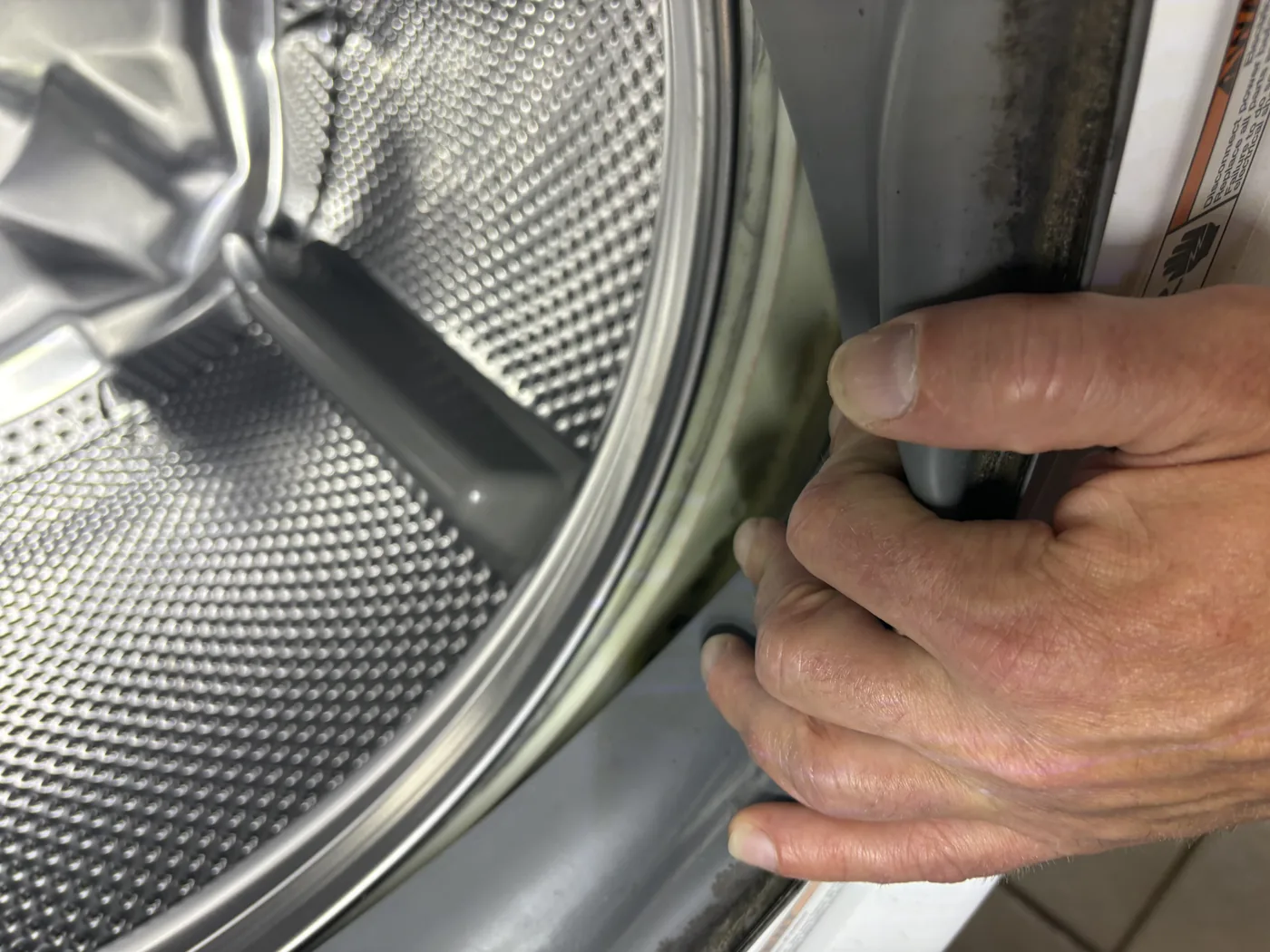 Close view of a washer door gasket during inspection